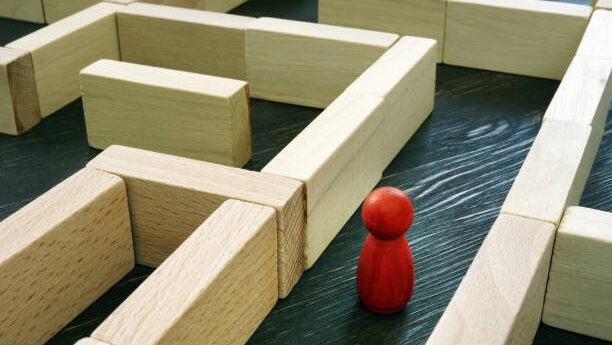 Small Red figurine inside the maze. Business challenge and finding a solution to the situation.
